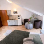Bračni krevet smje&scaron;ten uz prozor u standardnom trokrevetnom studiju u Herceg Novom.